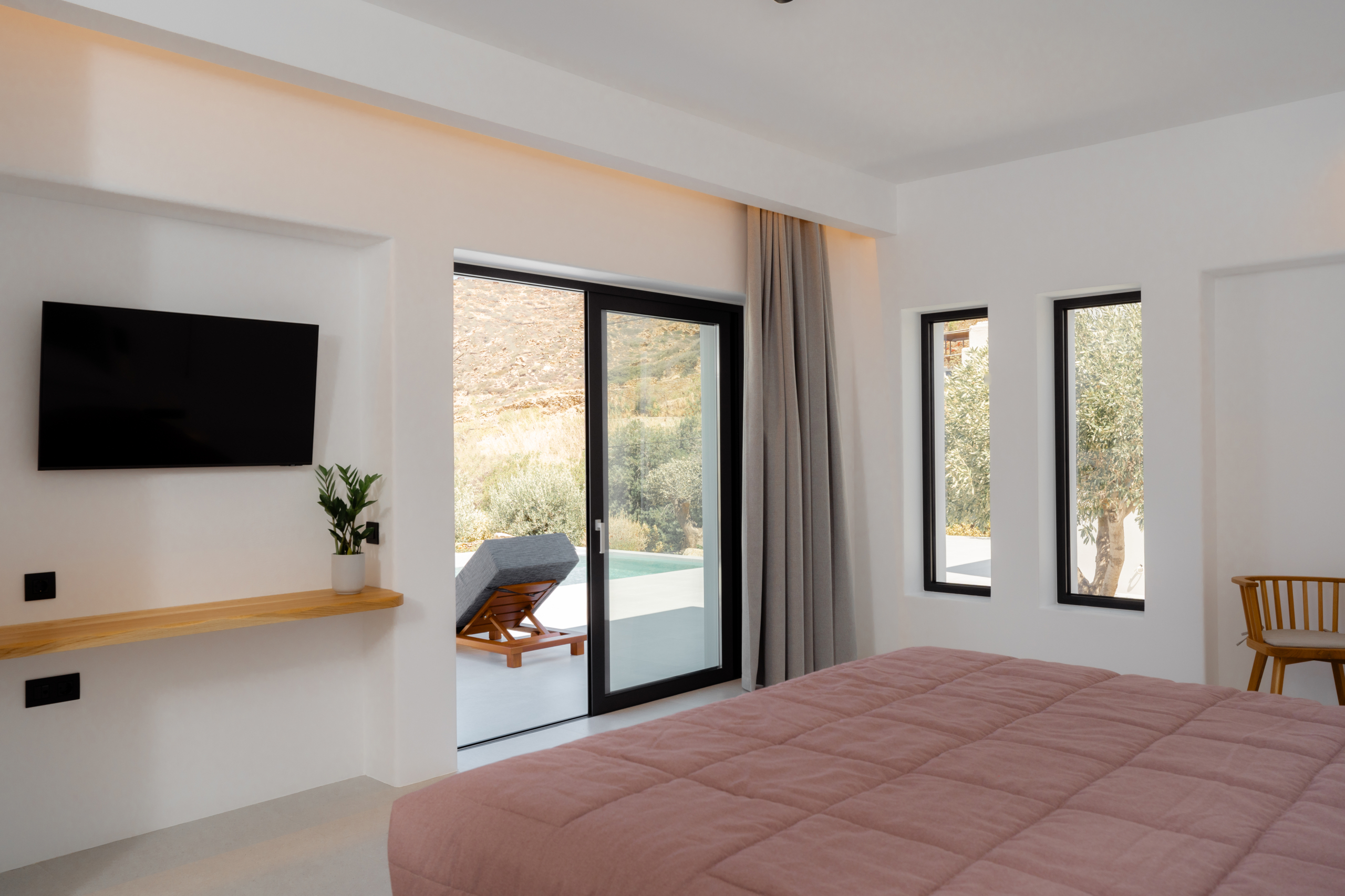 Bliss Hotel Ios suite bedroom with king-size bed and olive tree windows